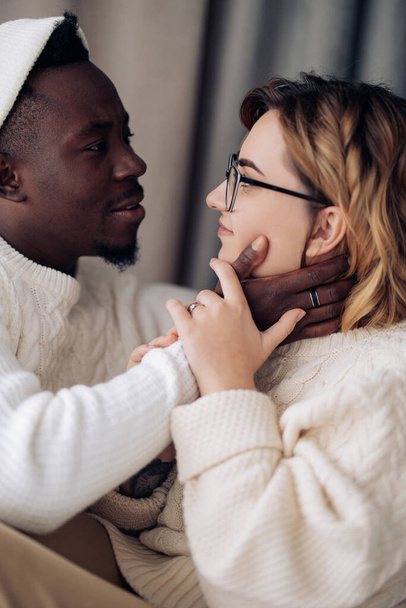 Portrait of happy interracial couple looking each other. Concept of interracial family and unity between different human races. - Photo, image