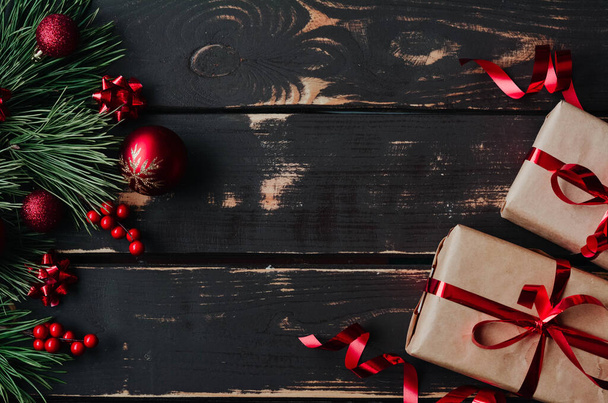 Vista superior foto Navidad flatlay cajas de regalo, juguetes de árbol de Navidad rojo y brance de abeto sobre fondo de madera. Fondo de Navidad con espacio para text.Copyspace. - Foto, Imagen