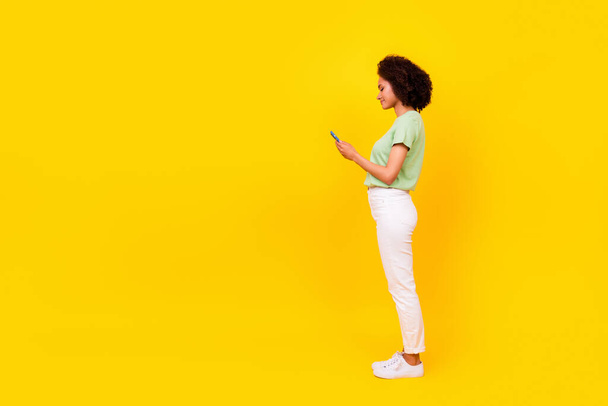 Full length photo of young pretty adorable nice woman girlish online blogger user new smartphone app advert isolated on bright yellow color background. - Fotoğraf, Görsel