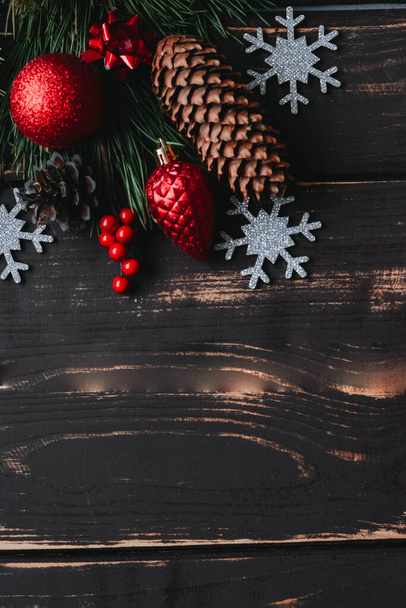 Noël fond rouge jouets arbre de Noël, flocon de neige argent et brance d'épinette sur fond en bois.. Fond de Noël avec de l'espace pour le texte.Espace de copie.Photo verticale. - Photo, image