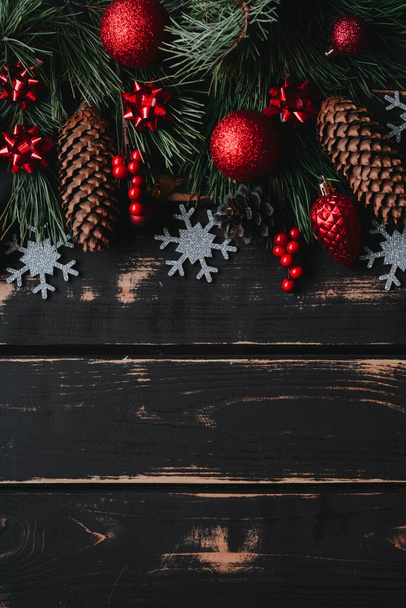 Kerst achtergrond rode kerstboom speelgoed, zilver sneeuwvlok en sparren brance op houten achtergrond.. Kerstmis achtergrond met ruimte voor tekst.Copyspace.Verticale foto. - Foto, afbeelding