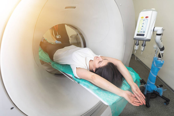 красивая женщина лежит на кровати КТ во время томографического теста в больнице
. - Фото, изображение