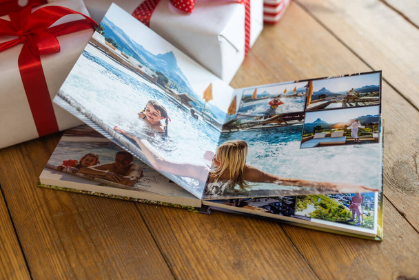 un livre photo de famille.Photobook est un cadeau. album photo à côté de cadeaux. - Photo, image