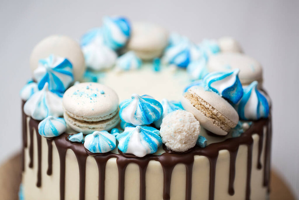 Cake with chocolate streaks, blue meringue and macaroons - Фото, изображение