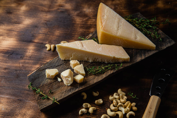 Τυρί παρμεζάνας σε σκούρο φόντο - Φωτογραφία, εικόνα