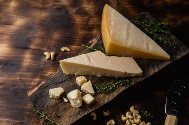 Parmezán sajt sötét háttérrel közelkép - Fotó, kép