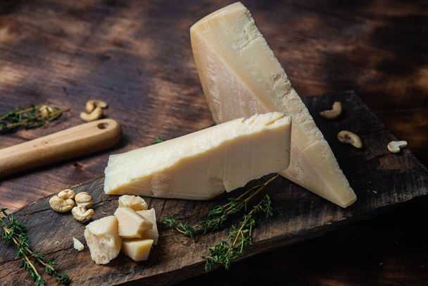 Τυρί παρμεζάνας σε σκούρο φόντο - Φωτογραφία, εικόνα