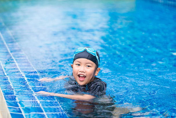 χαρούμενα παιδιά Χαμογελώντας χαριτωμένο κοριτσάκι με γυαλιά ηλίου στην πισίνα - Φωτογραφία, εικόνα