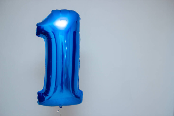 blue balloon foil number one on wall background - Zdjęcie, obraz