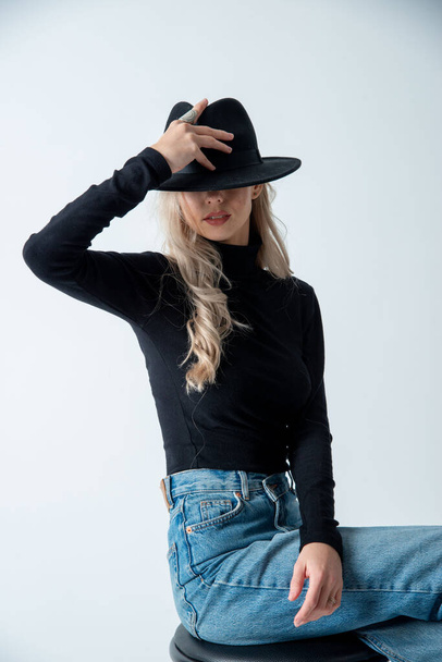 beautiful blonde woman posing with hat in studio - Zdjęcie, obraz