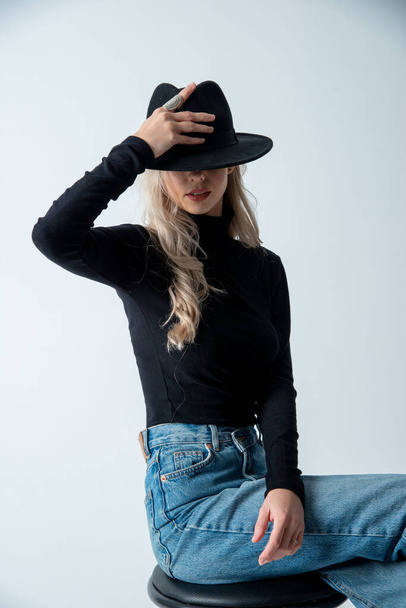 beautiful blonde woman posing with hat in studio - Foto, imagen