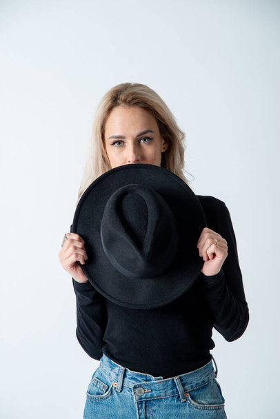 beautiful blonde woman posing with hat in studio - Foto, Imagen