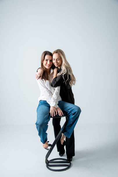 two beautiful women brunette and blonde posing in studio - Photo, image