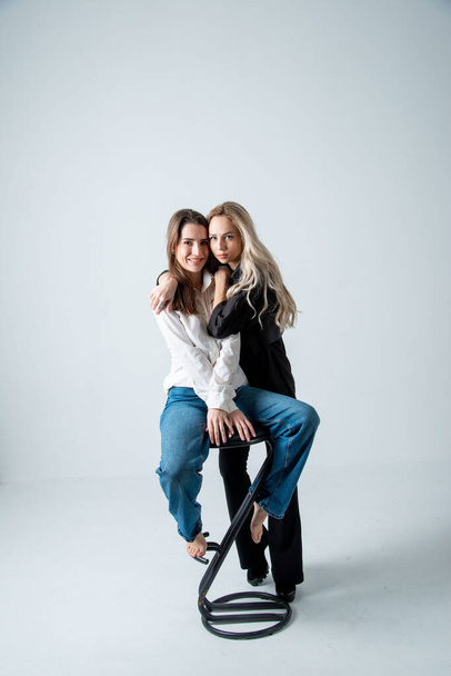 two beautiful women brunette and blonde posing in studio - Fotoğraf, Görsel