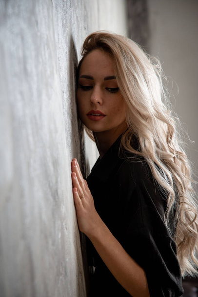 beautiful blonde woman in black, posing in studio - Foto, Imagen
