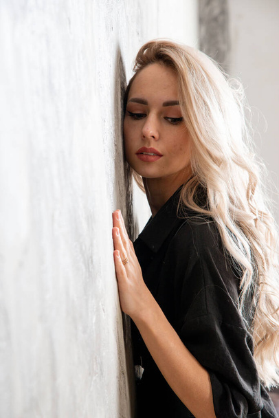 beautiful blonde woman in black, posing in studio - Photo, Image