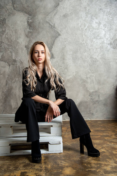 beautiful blonde woman in black, posing in studio - Foto, imagen