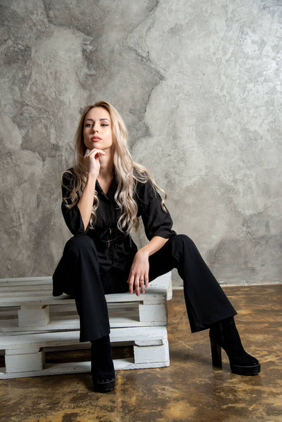 beautiful blonde woman in black, posing in studio - Foto, afbeelding