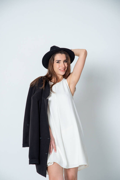 brunette woman posing in white dress and hat - Photo, image