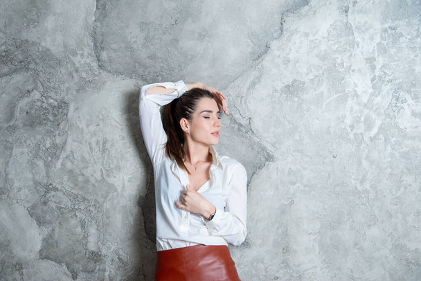 beautiful brunette posing against gray wall - Foto, Imagem