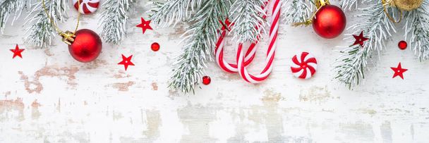 Christmas holiday decorations at white background. Fir tree, baubles, candy . Long banner format. - Foto, imagen