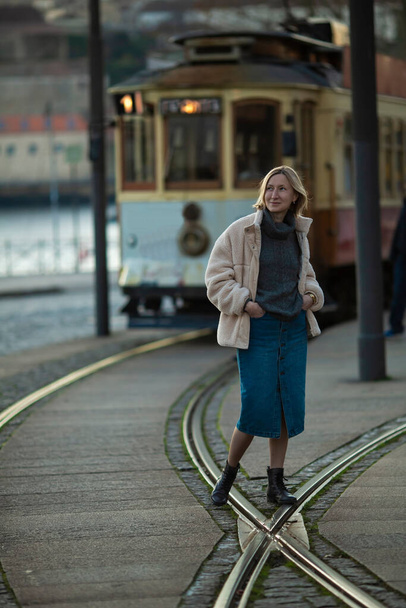 A woman stands near a vintage streetcar. - Foto, Bild