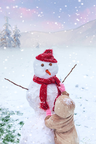As crianças fazem um boneco de neve no inverno. Foco seletivo. Miúdo. - Foto, Imagem