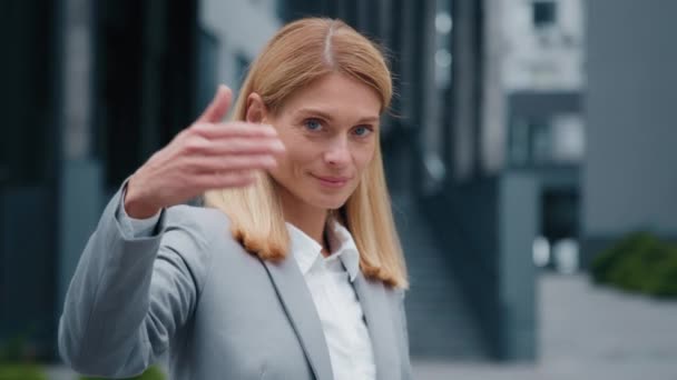 Close-up caucasian businesswoman standing in outdoors on city HR manager invites candidate for position waving hand makes come here beckoning gesture welcome business woman goes away blurred back view - Footage, Video