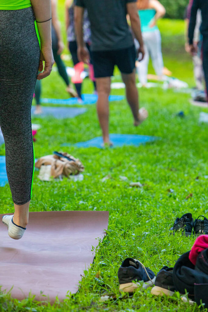 Lviv, Ukrayna - 2 Temmuz 2021: Şehir parkındaki birçok insan yoga yapıyor. - Fotoğraf, Görsel