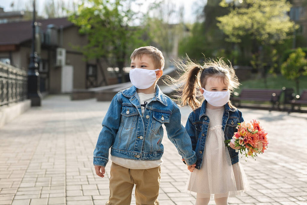 Child boy and girl walking outdoors with face mask protection. Coronavirus, covid-19 - Valokuva, kuva