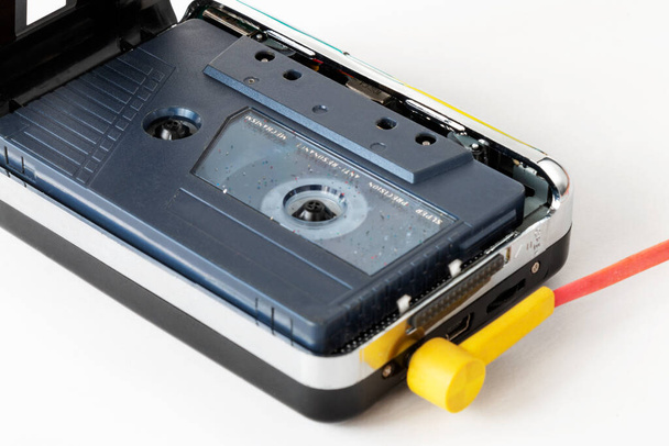 Tragbarer Kassettenspieler mit Kopfhörer und Kassettenband isoliert auf weißem Hintergrund, Geräte für die 70er-80er-90er - Foto, Bild