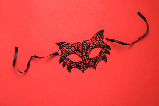 Seksowna koronkowa maska kota na czerwonym tle. Karnawał. Role odgrywają seksualne gierki. Widok z góry - Zdjęcie, obraz