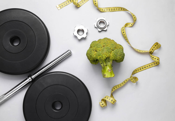 Fitness, koncepce hubnutí. Barbell s měřicí páskou a brokolicí izolované na bílém pozadí. Horní pohled - Fotografie, Obrázek