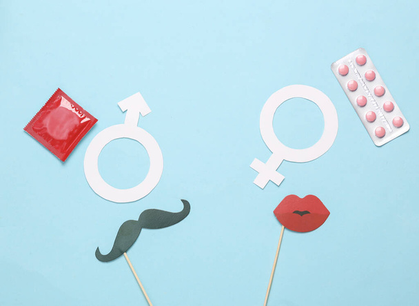 Contraception concept, safe sex, birth control/ Male and female gender symbol, mustache and lips on a stick, birth control pills and condoms - Photo, Image