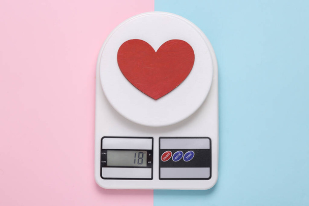 Kuchnia wagi elektroniczne z sercem na różowym niebieskim tle. Widok z góry - Zdjęcie, obraz