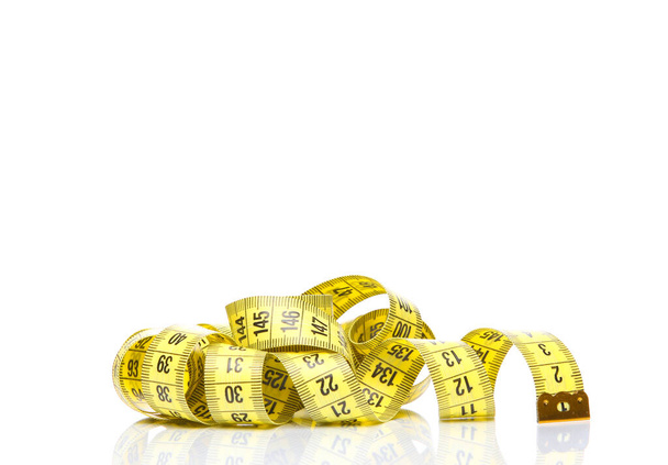 白い背景に反射して分離された黄色の測定テープ。ダイエット、減量、コンセプト - 写真・画像