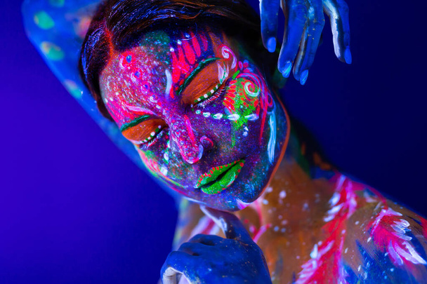 Body art glowing in ultraviolet light. Body art on the body and hand of a girl glowing in the ultraviolet light - Photo, Image