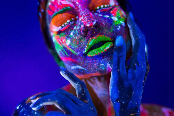 Body art glowing in ultraviolet light. Body art on the body and hand of a girl glowing in the ultraviolet light - Foto, immagini