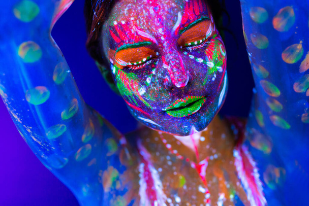 Portrait of a girl painted in fluorescent powder. - Photo, Image