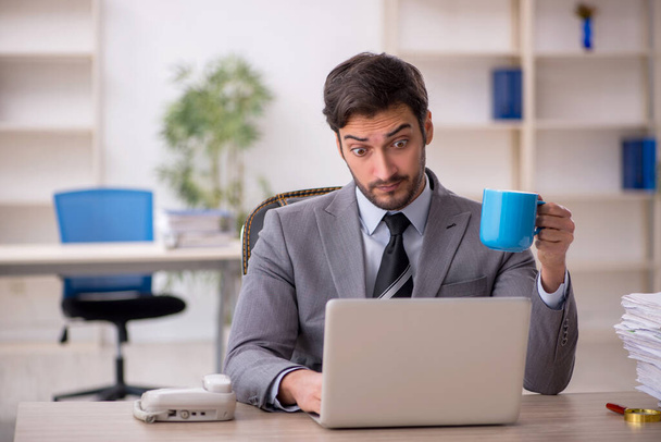 Young businessman employee drinking coffee during break - Photo, image