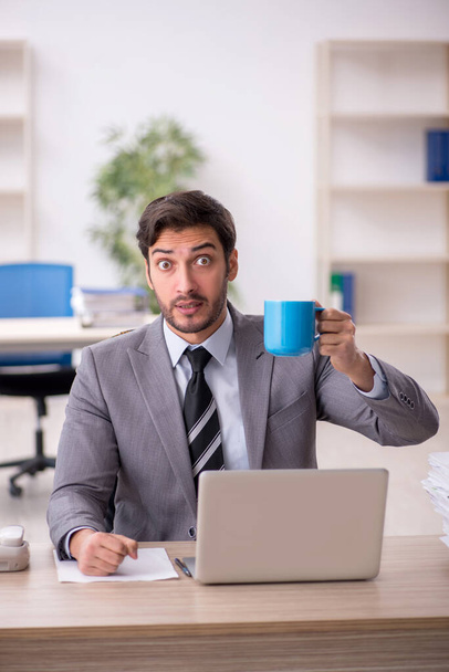 Young businessman employee drinking coffee during break - Фото, зображення