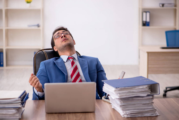Jeune homme d'affaires assis sur le lieu de travail - Photo, image