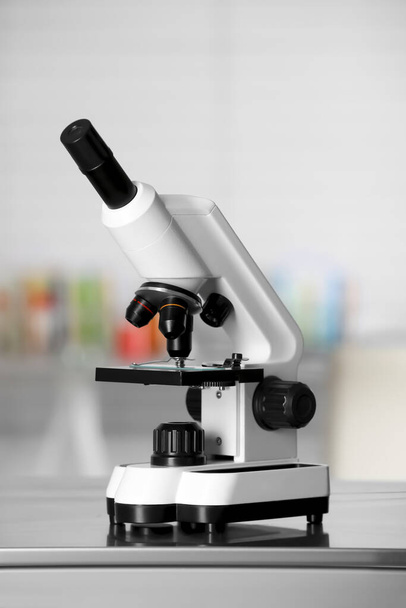 Modern medical microscope on metal table in laboratory - Φωτογραφία, εικόνα