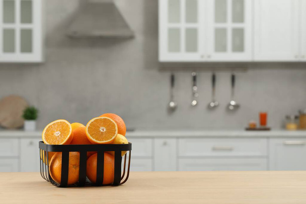 Fresh ripe oranges on wooden table in kitchen, space for text - Foto, immagini