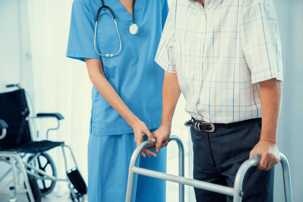 Physiotherapist assists her contented senior patient on folding walker. Recuperation for elderly, seniors care, nursing home. - Fotó, kép