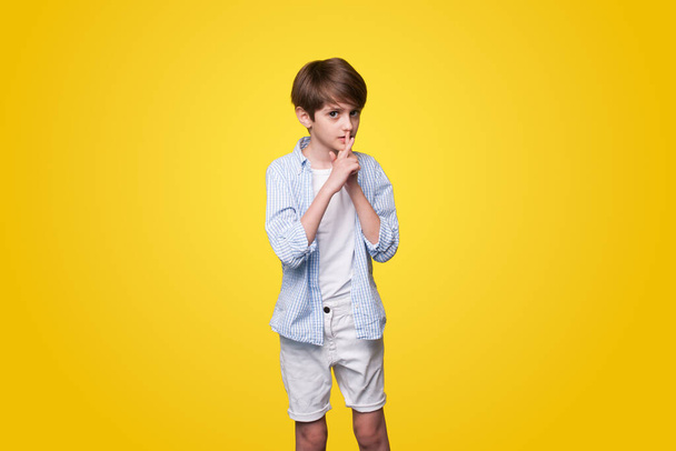 Een bange jongen die emotie uitdrukt geïsoleerd over een gele achtergrond wit. Eenzaamheid, stress en angst. - Foto, afbeelding