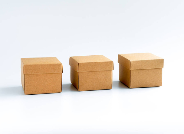 Три картонні коробки ізольовані на білому тлі. Коробка подарункова коробка, подарунки. Квадратна крафт-паперова коробка з кришкою зверху. Доставка, посилка, упаковка з концепціями онлайн-покупки та доставки
. - Фото, зображення