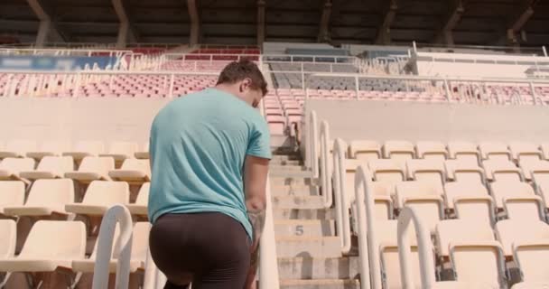 Male athlete running on stadium stairs on a beautiful sunny day - Footage, Video