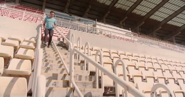 Joven atleta masculino corriendo en las escaleras del estadio - Metraje, vídeo