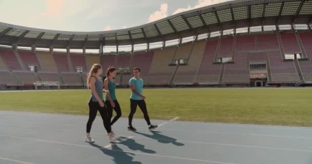 Tres personas caminando al hipódromo en el estadio - Metraje, vídeo